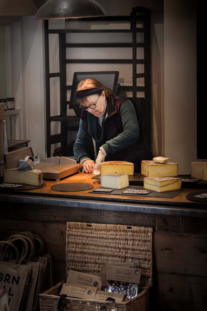 Deli owner at the counter, Corn Hall Deli, Cirencester — hospitality and brand photography by Lou Carruthers