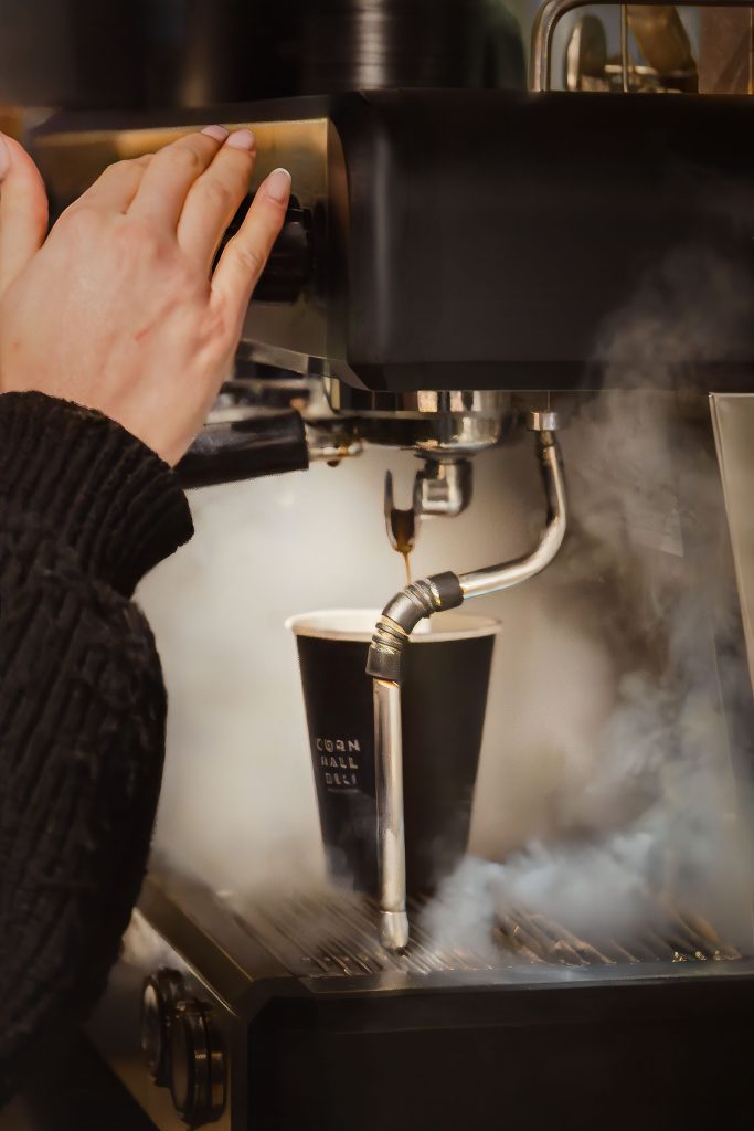 Close-up coffee pour detail at Corn Hall Deli, Cirencester — hospitality photography by Lou Carruthers