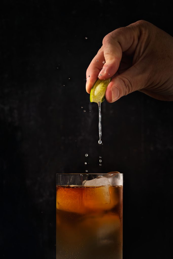 Bartender garnishing Haka Rum cocktail action shot, professional drinks photographer Lou Carruthers UK