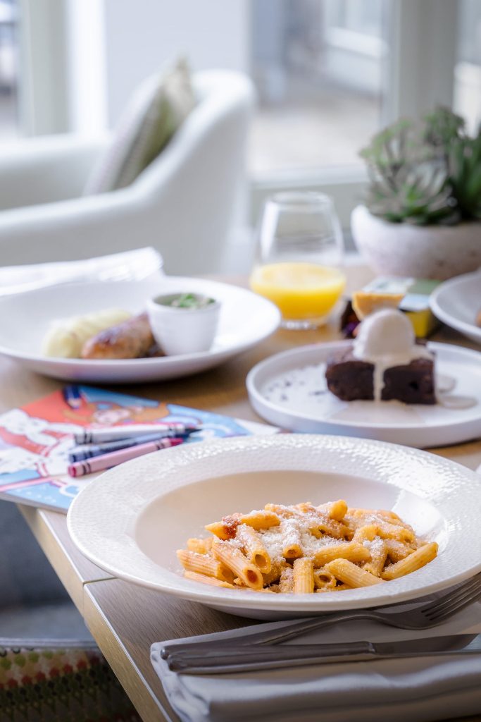 Seasonal pasta dish served alongside dessert and drinks on a bright dining table at Siddington Park, styled for relaxed hospitality dining, photographed by Lou Carruthers, Lou Carruthers Photography, Hospitality & Drinks Photographer, Cotswolds and Menorca